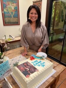 Maryann standing over a retirement cake